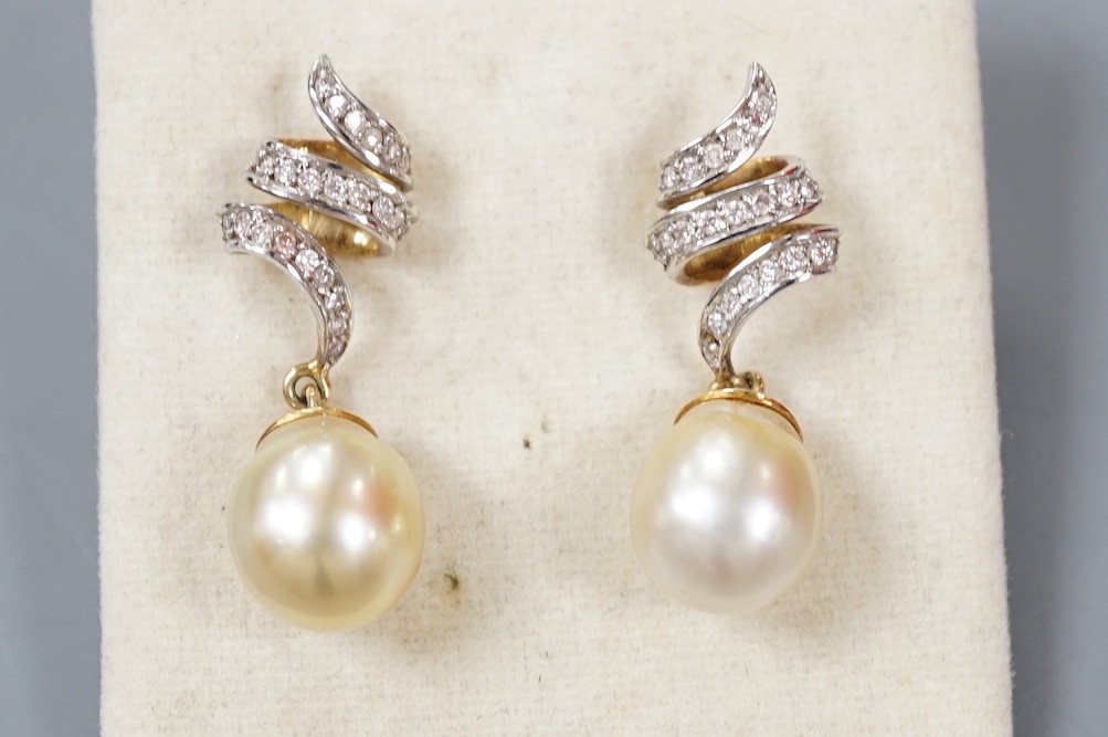 A modern pair of yellow metal, cultured pearl and diamond set scroll drop drop earrings, overall 34mm, gross weight 10.3 grams.